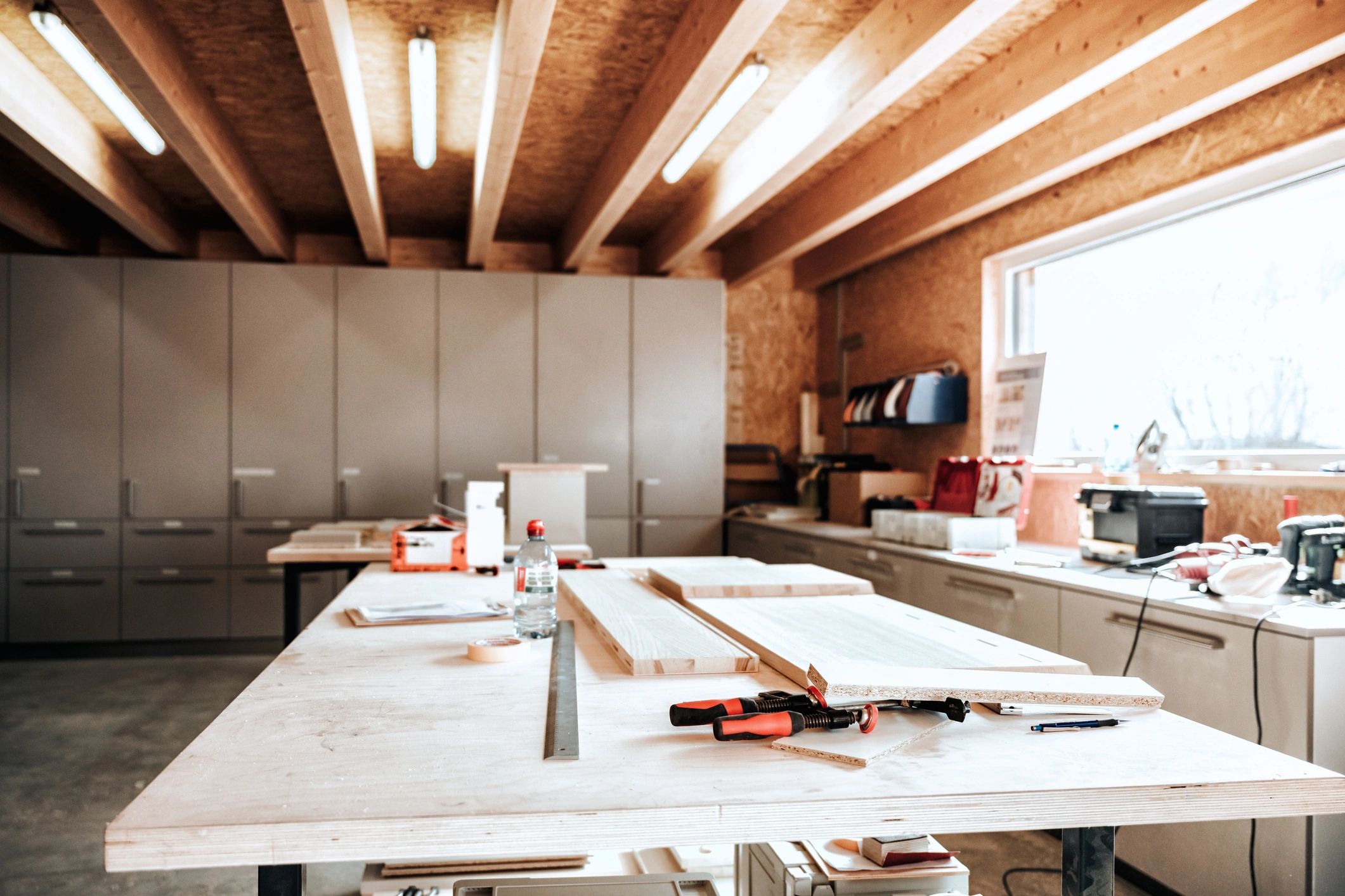 Workbench with wood planks and tools in a carpentry shop