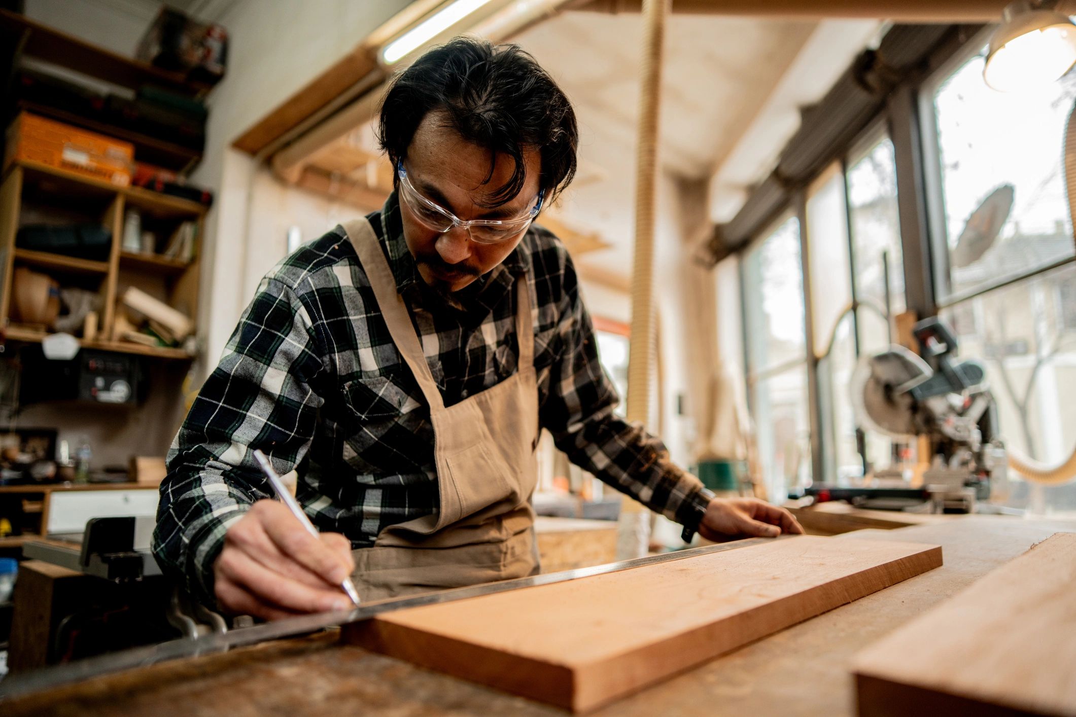 Carpenter measuring wood in a workshop