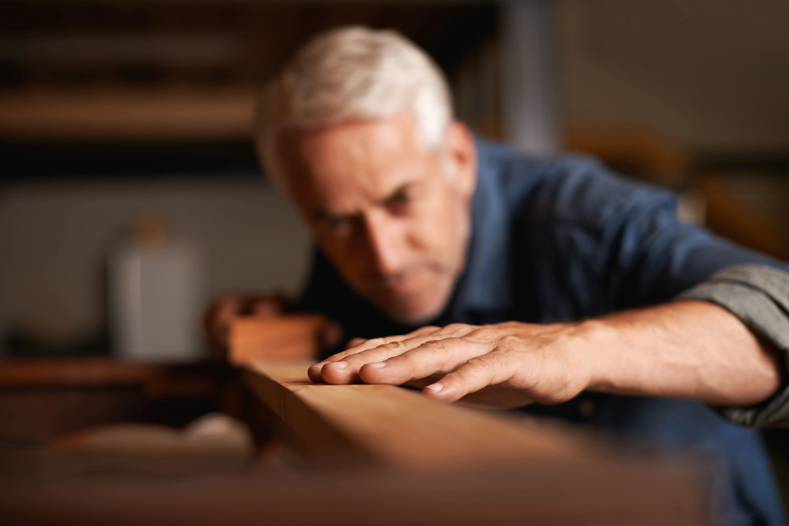 Craftsman sanding wood in a woodworking studio